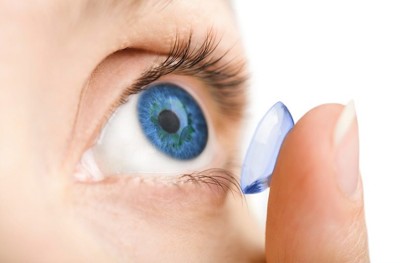 Nahaufnahme eines menschlichen Auges bei Kühnis Optik in Gossau, bei der eine transparente Kontaktlinse präzise auf die Hornhaut angepasst wird.